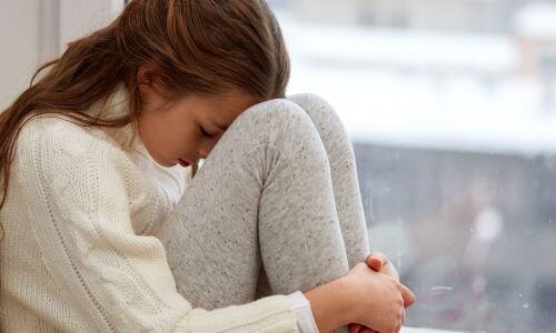 Young girl head on knees